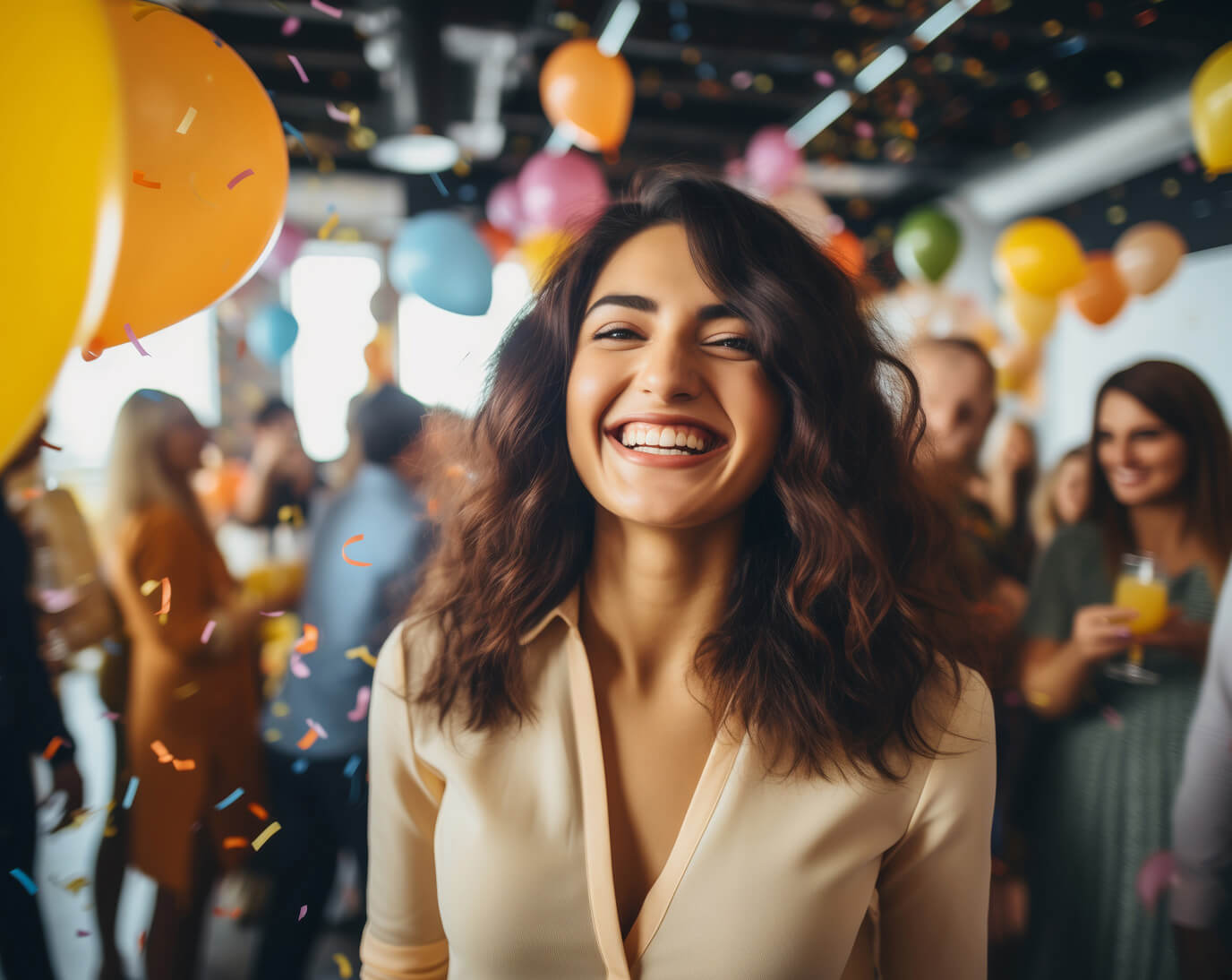 Eine lächelnde Frau steht im Vordergrund einer Feier. Um sie herum schweben bunte Ballons und Konfetti. Im Hintergrund sind verschwommene Menschen, die Getränke in der Hand halten. Fröhliche und festliche Atmosphäre.